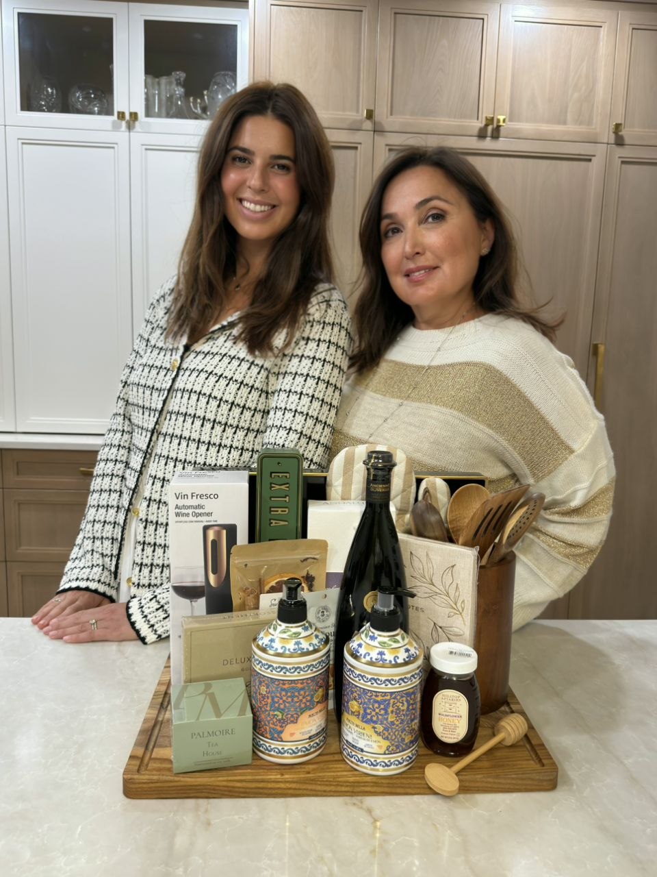Two women standing behind a curated closing gift in a kitchen