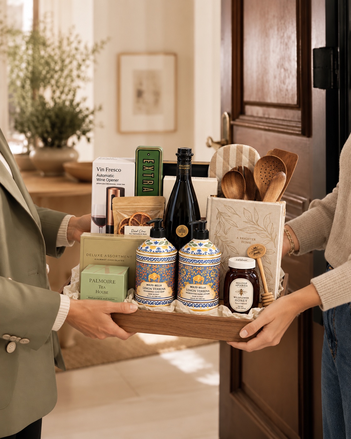 The Concierge Collection carefully handed to a client at their front door, with both people supporting the wooden gift tray